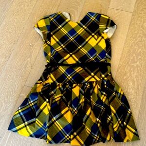 This is a blue and yellow dress for kids! It has a belt with a bow tied to it.